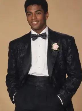 AI-generated portrait of a man in a black tuxedo with a bow tie and a pink rose boutonniere